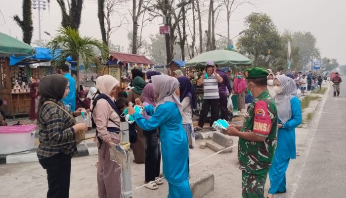 Babinsa dan Petugas Kesehatan Bagikan Masker di Pasar Pelalawan